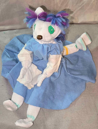 White with yellow, pink, and green accents and purple hair.